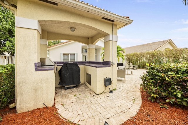 view of patio with an outdoor kitchen and a grill