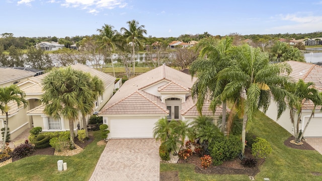 view of front of property with a garage, a water view, and a front yard