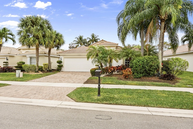 mediterranean / spanish-style house with a garage and a front lawn