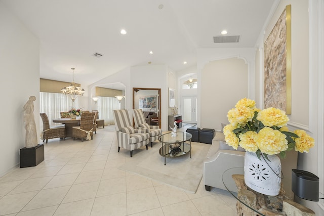 tiled living room with a notable chandelier and lofted ceiling