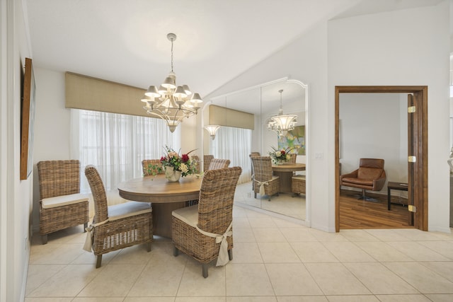 dining area featuring an inviting chandelier, light tile patterned floors, and lofted ceiling