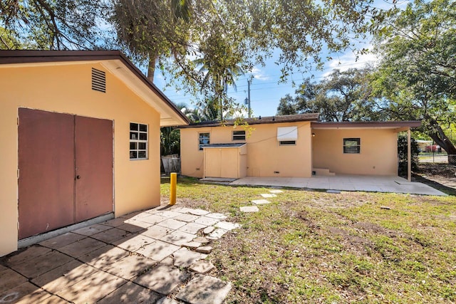 back of house with a yard and a patio