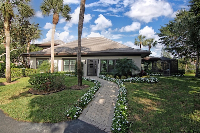 view of front of house featuring a lanai and a front lawn