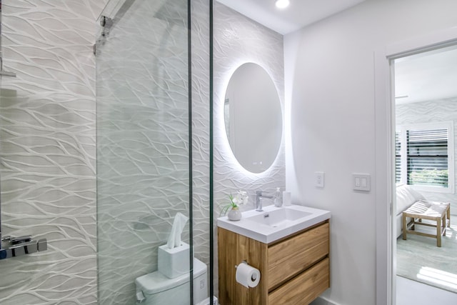 bathroom with vanity, toilet, and tile walls