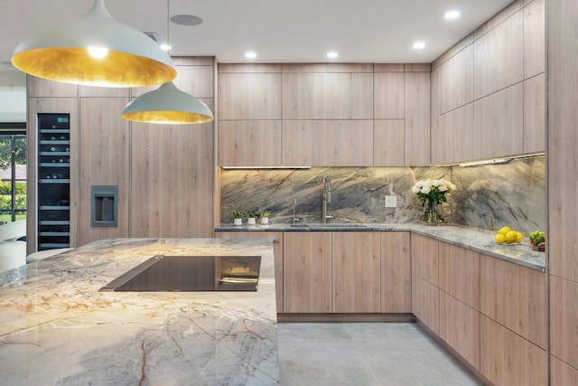 kitchen with pendant lighting, light brown cabinetry, and light stone counters