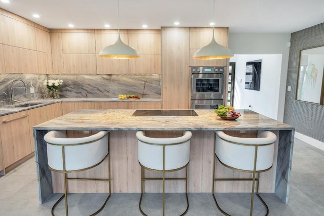 kitchen with sink, hanging light fixtures, light brown cabinets, and a breakfast bar