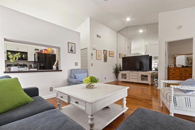 living room featuring wood-type flooring and lofted ceiling