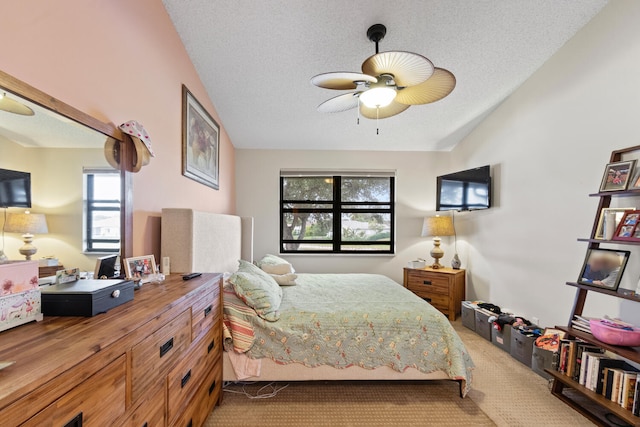 carpeted bedroom with ceiling fan and a textured ceiling