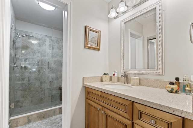 bathroom featuring a shower with door and vanity