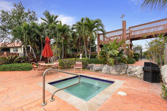 view of pool featuring area for grilling, an in ground hot tub, a patio, and a deck