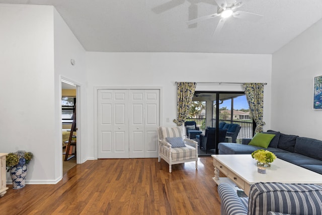 living room featuring dark wood-type flooring, a textured ceiling, and ceiling fan