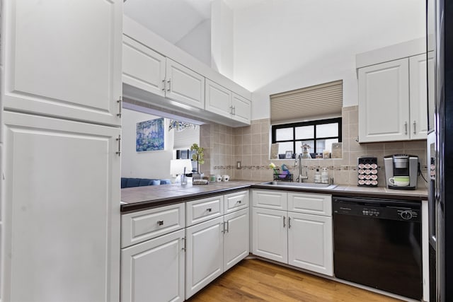 kitchen with tasteful backsplash, white cabinetry, sink, black appliances, and light hardwood / wood-style flooring