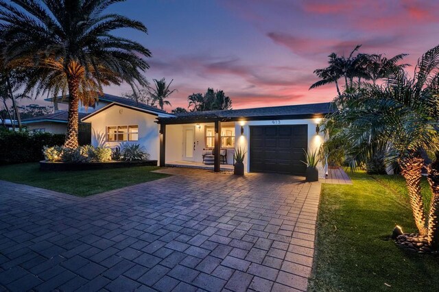 single story home with a lawn and a garage