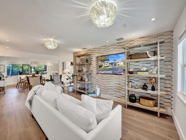 living room featuring an inviting chandelier and light hardwood / wood-style floors