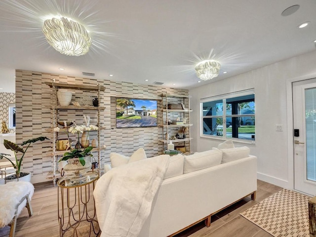 living room with light wood-type flooring and a notable chandelier