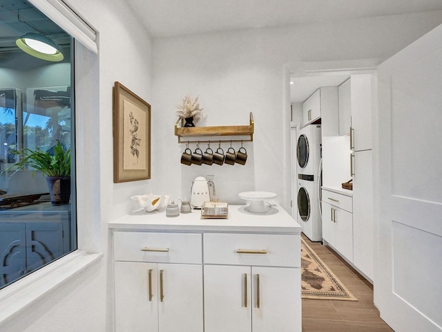 washroom with dark hardwood / wood-style flooring and stacked washer / dryer