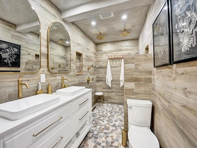 bathroom featuring toilet, vanity, and a shower