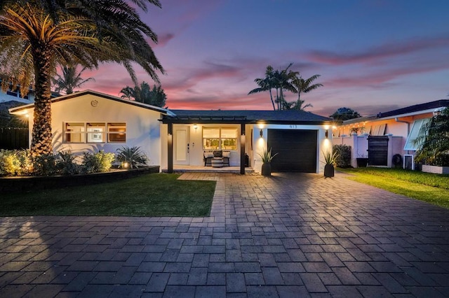 view of front facade featuring a garage and a lawn