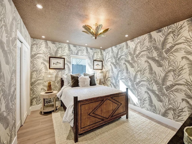 bedroom with light hardwood / wood-style floors and a textured ceiling