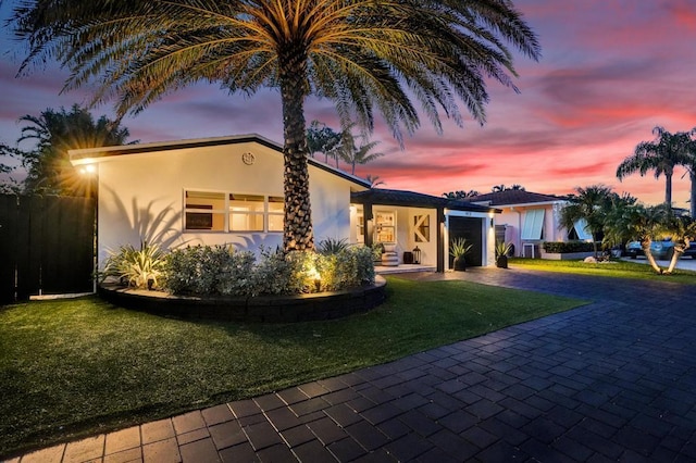 view of front of home featuring a garage and a lawn