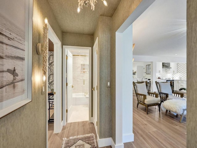 hall featuring light hardwood / wood-style flooring and a notable chandelier