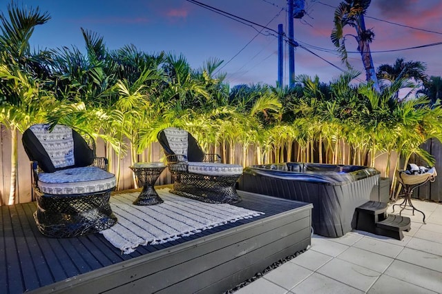 deck at dusk with a hot tub