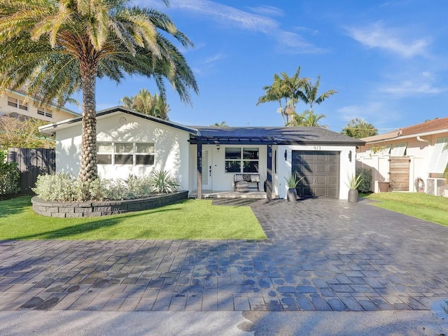 view of front of home with a front yard and a garage