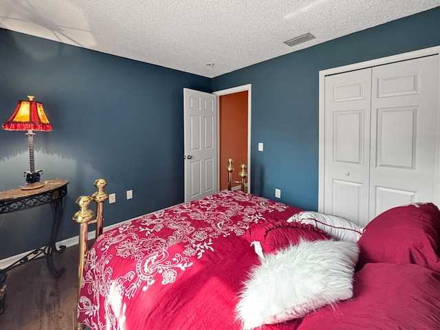 bedroom with hardwood / wood-style flooring, a textured ceiling, and a closet