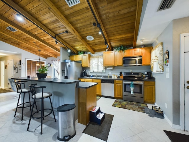 kitchen featuring wooden ceiling, track lighting, vaulted ceiling with beams, a breakfast bar, and stainless steel appliances