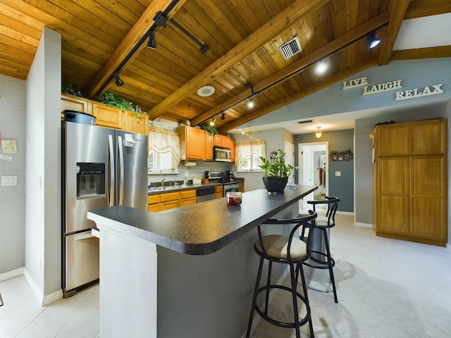 kitchen with a kitchen island, vaulted ceiling with beams, appliances with stainless steel finishes, and wooden ceiling