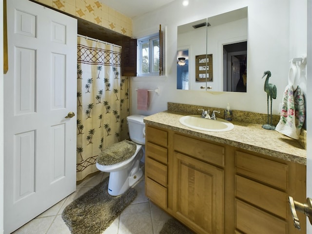 bathroom featuring toilet, tile patterned flooring, walk in shower, and vanity