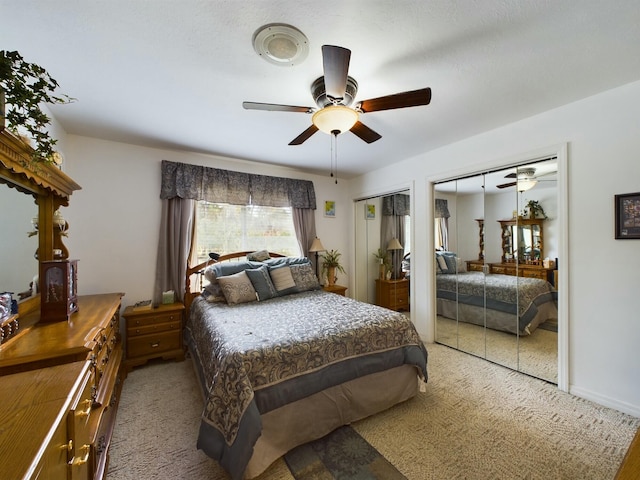 carpeted bedroom featuring two closets and ceiling fan