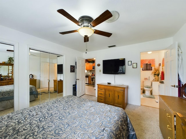 bedroom with light colored carpet, ensuite bath, and ceiling fan