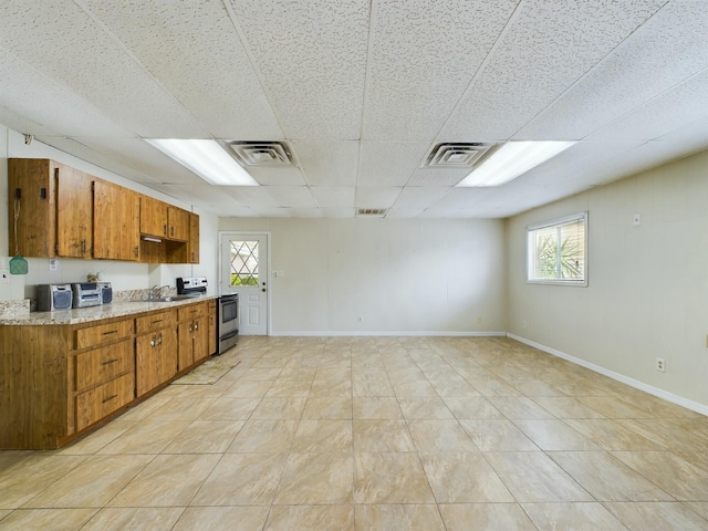 kitchen featuring electric stove, a paneled ceiling, and sink