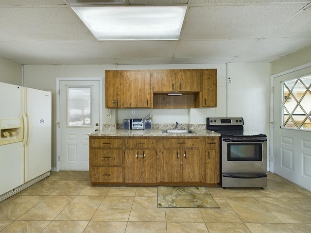 kitchen with stainless steel electric stove, sink, white fridge with ice dispenser, and a paneled ceiling