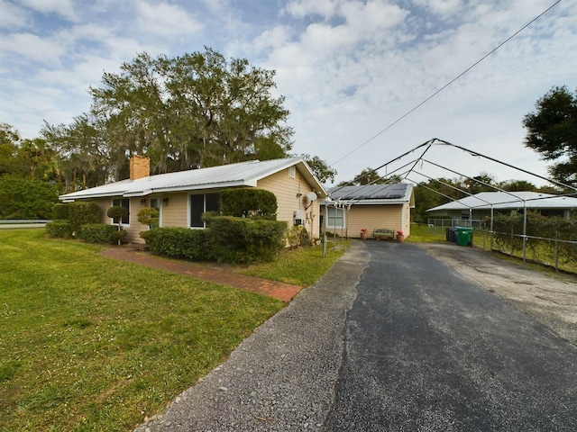 view of front of property with a carport and a front lawn