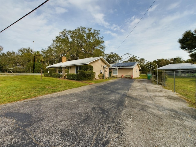 view of front facade with a front lawn and solar panels