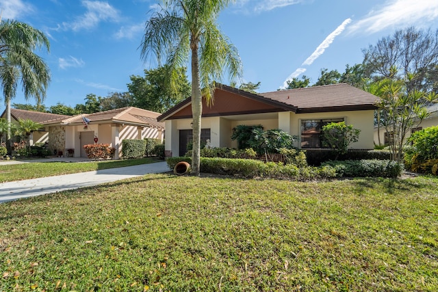 ranch-style home featuring concrete driveway, stucco siding, a tiled roof, and a front lawn