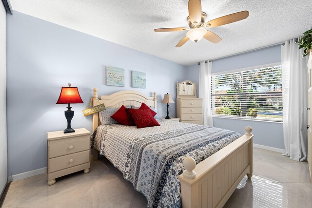 bedroom featuring light tile patterned floors, a closet, a textured ceiling, and ceiling fan