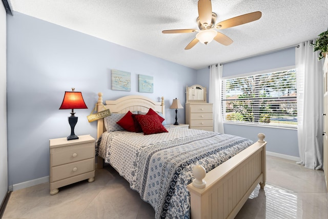 bedroom featuring a textured ceiling, ceiling fan, and baseboards