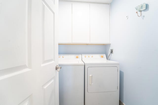washroom featuring washer and dryer and cabinet space