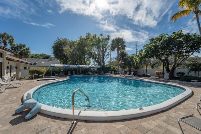 view of swimming pool with a jacuzzi and a patio