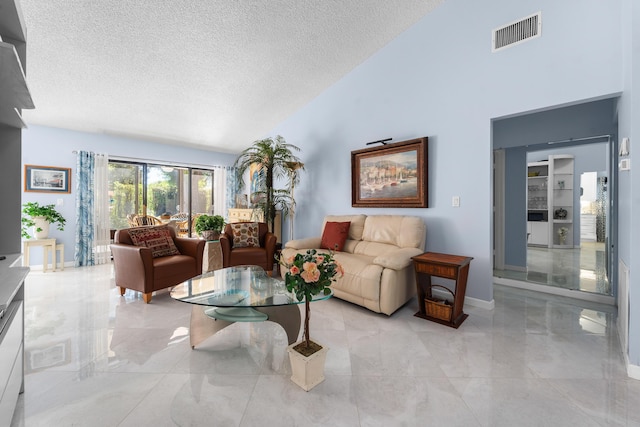 interior space with baseboards, a textured ceiling, visible vents, high vaulted ceiling, and marble finish floor