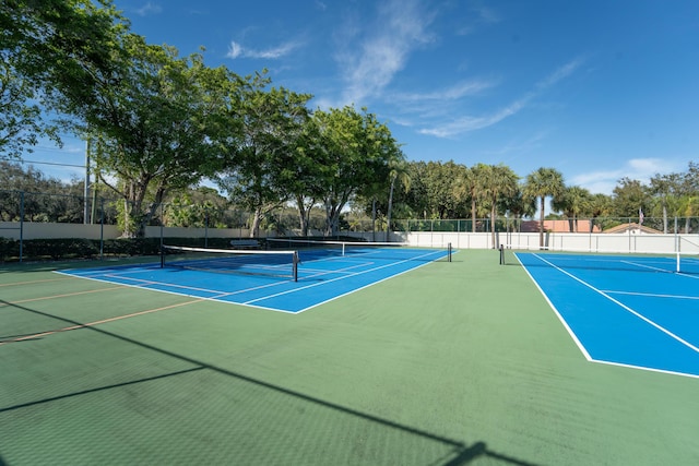 view of tennis court featuring community basketball court and fence