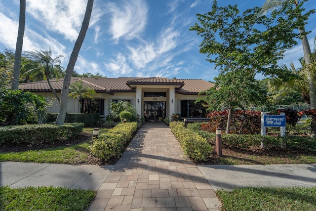 mediterranean / spanish house featuring stucco siding and a tile roof