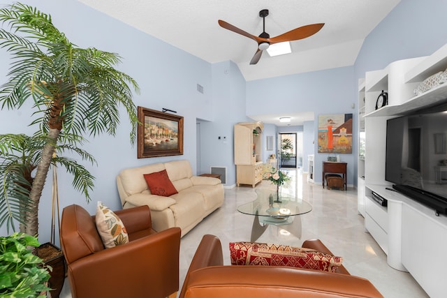 living area featuring high vaulted ceiling, a wood stove, and a ceiling fan