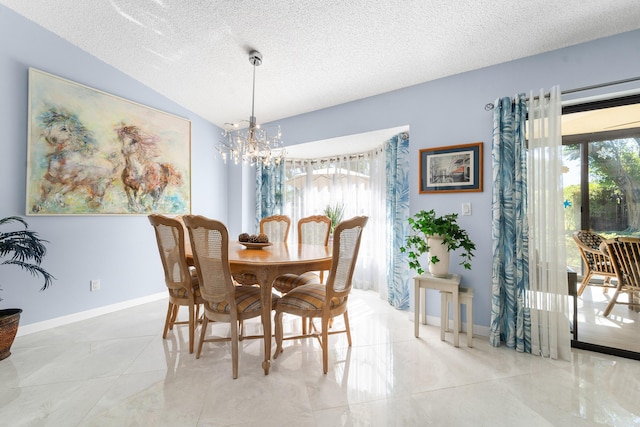 dining space featuring a chandelier, a textured ceiling, baseboards, and vaulted ceiling