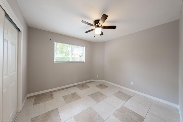 unfurnished bedroom featuring ceiling fan and a closet