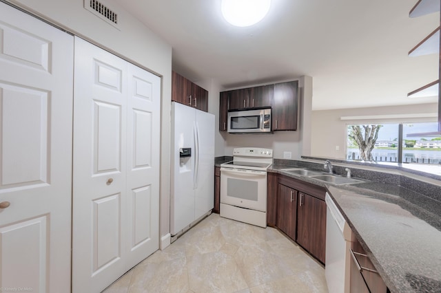 kitchen with sink, dark brown cabinetry, and white appliances