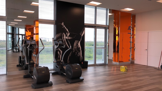 gym with a wall of windows and hardwood / wood-style floors